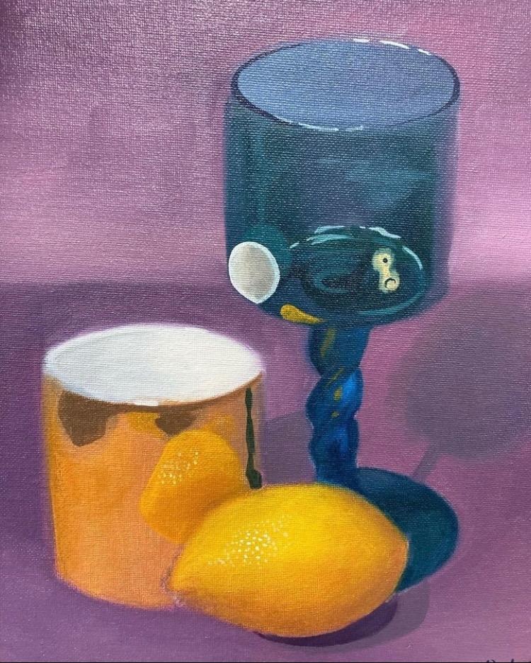 A lemon and two colorful vessels against a purple background